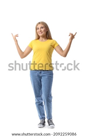 Portrait of stylish woman pointing at something on white background