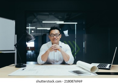 Portrait Of Successful Asian Male Architect Smiling And Looking At Camera, Working On Project Plan Drawing In Design Studio Office