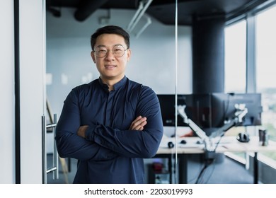 Portrait Of Successful Asian Programmer, Team Leader Company Owner Smiling And Looking At Camera With Crossed Arms, Talented Startup Entrepreneur Working Inside IT Office.