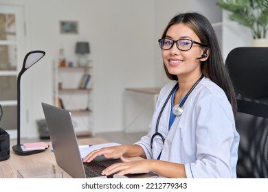 Portrait Of Successful Asian Young Female Doctor At Modern Workplace Using Laptop For Video Conference Chat With Patient During Virtual Consultation. Excellent Service, Online Visit To Therapist