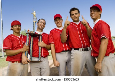 Portrait Of Successful Baseball Team With Trophy On Field