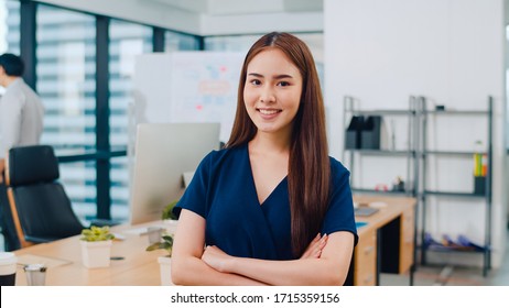 Portrait Of Successful Beautiful Executive Businesswoman Smart Casual Wear Looking At Camera And Smile, Arms Crossed In Modern Office Workplace. Young Asia Lady Standing In Contemporary Meeting Room.