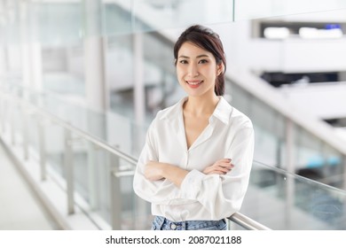 Portrait of successful business asian women in white shirt. with arms crossed and smile , Young businesswoman smiling and looking at camera, Happy feeling concept