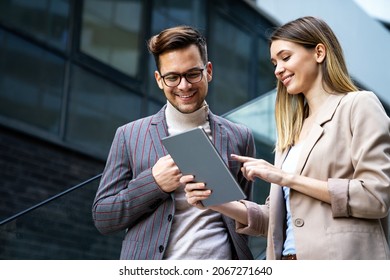 Portrait of successful business people working, talking together in urban background. - Shutterstock ID 2067271640