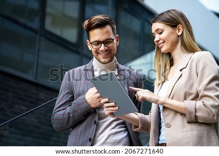 Portrait of successful business people working, talking together in urban background.