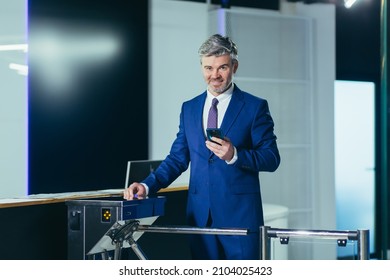 Portrait of a successful businessman with a beard, a man happily enters the office with a turnstile on a magnetic card - Powered by Shutterstock