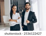 Portrait of successful businesspeople wearing stylish formal wear, fashion model posing, looking at camera in modern office. Advertisement concept