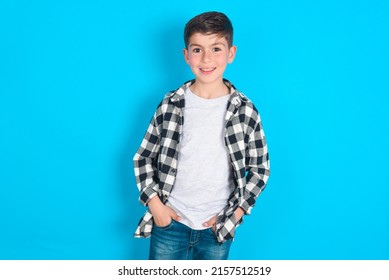 Portrait of successful caucasian kid boy wearing plaid shirt over blue background, smiling broadly with self-assured expression. Confidence and business concept. - Powered by Shutterstock