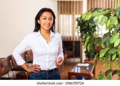 Portrait Of Successful Confident Latin American Business Woman Standing In Modern Office Interior, Looking At Camera With Smile.