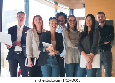 Portrait of successful creative business team looking at camera and smiling. Diverse business people standing together at startup.