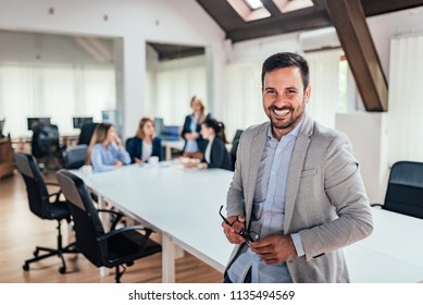Portrait of successful entrepreneur, colleagues working in the background. - Shutterstock ID 1135494569