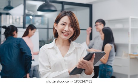 Portrait Of Successful Executive Businesswoman Smart Casual Wear Looking At Camera And Smile With Digital Table In Modern Office Workplace. Young Asia Lady Standing Relax In Contemporary Meeting Room.