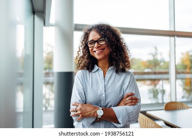 Portrait Of Successful Female Professional With Her Arms Crossed. Smiling Businesswoman Standing In Office.