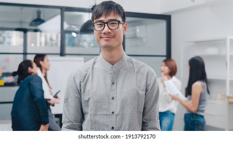 Portrait of successful handsome executive businessman smart casual wear looking at camera and smiling, happy in modern office workplace. Young Asia guy standing relax in contemporary meeting room. - Powered by Shutterstock