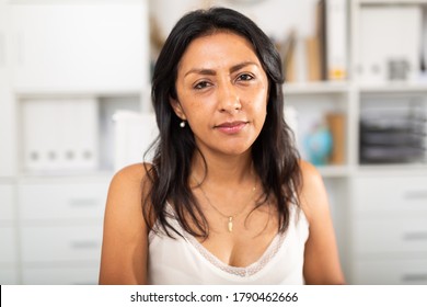 Portrait Of Successful Latin American Business Woman Dressed In Casual Wear In Office Interior