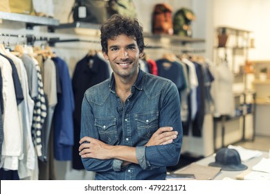 Portrait Of Successful Male Owner  With Crossed Arms In Clothing Store. Looking At Camera