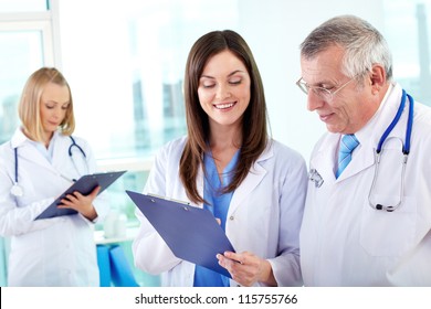 Portrait Of Successful Medical Workers Discussing Plan In Hospital