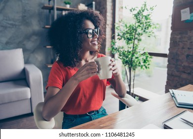 Portrait of successful professional accountant sitting at desktop in modern office drinking hot beverage holding mug with tea in hands looking at window enjoying free time