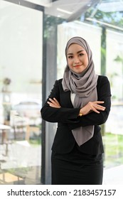 Portrait, Successful And Professional Young Asian Muslim Businesswoman Or Female Executive Manager In Formal Suit Stands In The Office With Her Arms Crossed.