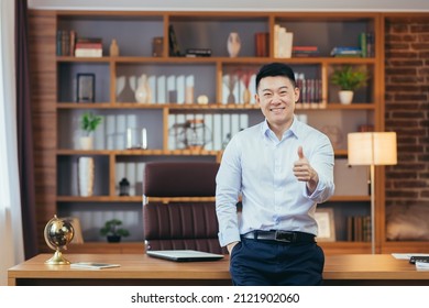Portrait of a successful university principal, Asian teacher in a shirt looks at the camera and smiles, keeps his finger up, encourages young people to study at the university - Shutterstock ID 2121902060