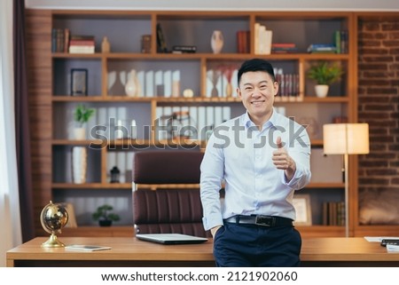 Portrait of a successful university principal, Asian teacher in a shirt looks at the camera and smiles, keeps his finger up, encourages young people to study at the university ストックフォト © 