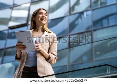 Portrait of successful woman using digital tablet in urban background. Business people concept