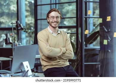 Portrait Of Successful Young IT Specialist Young Engineer Programmer In Modern Loft Office Smiling And Looking Camera With Crossed Arms, Businessman Business Owner Wearing Glasses And Casual Clothes