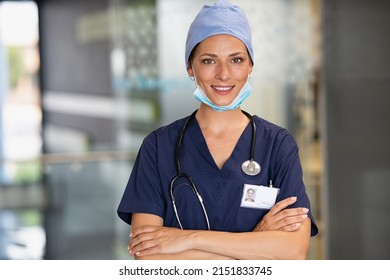 Portrait of  successfurl young woman doctor wearing face mask and scrubs in hospital. Confident and reliable medical practitioner with surgical mask looking at camera. Smiling nurse standing in clinic - Shutterstock ID 2151833745