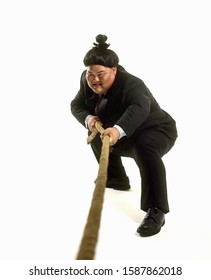 Portrait Of A Sumo Wrestler In A Business Suit Playing Tug-of-war