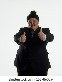 Portrait Of A Sumo Wrestler In A Business Suit Giving Two Thumbs Up