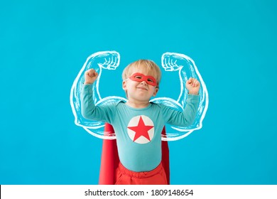 Portrait Of Superhero Child. Super Hero Kid Against Blue Background. Success And Winner Concept