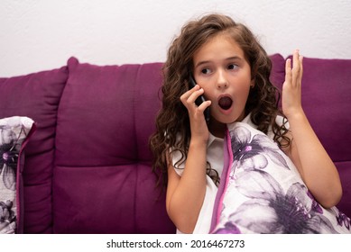 Portrait Of A Suprised Kid Girl Talking On A Smartphone Mobile.