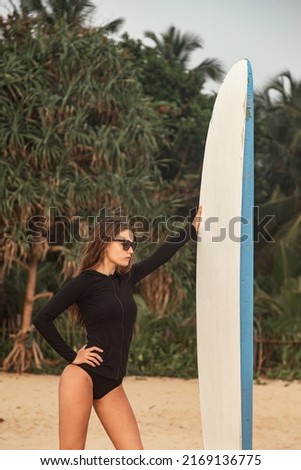 Similar – Surfer woman with bikini and wetsuit holding surfboard