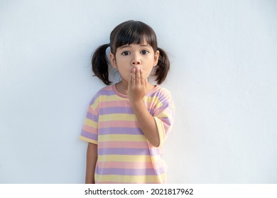 Portrait surprised cute little toddler girl child standing isolated over white background  Looking at the camera  hands near open mouth