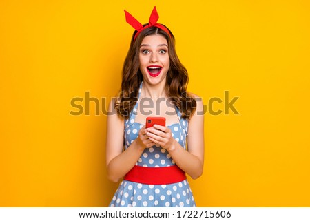 Portrait surprised energetic blogger girl use cell phone read social network news impressed scream wow omg wear blue polka-dot retro style outfit isolated bright shine color background