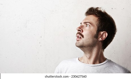 Portrait Of A Surprised Young Man Looking Up