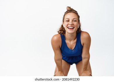 Portrait Of Sweaty Fitness Woman Smiling, Leaning On Knees And Looking Satisfied After Workout. Athlete Running On Track With Pleased Face, White Background