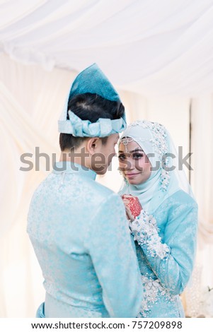 Portrait of sweet lovely young couple with traditional wedding dress standing on bridal dais.Selective focus