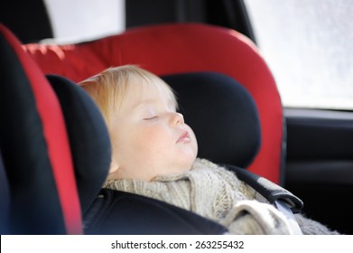 Portrait Of Sweet Toddler Boy Sleeping In Car Seat