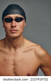 Portrait Of A Swimmer In A Cap And Mask, Half-length Portrait, Young Athlete Swimmer Wearing A Cap And Mask For Swimming, Copies Of Space, Gray Background.