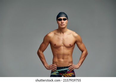 Portrait Of A Swimmer In A Cap And Mask, Half-length Portrait, Young Athlete Swimmer Wearing A Cap And Mask For Swimming, Copies Of Space, Gray Background.