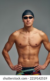 Portrait Of A Swimmer In A Cap And Mask, Half-length Portrait, Young Athlete Swimmer Wearing A Cap And Mask For Swimming, Copies Of Space, Gray Background.