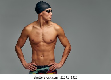 Portrait Of A Swimmer In A Cap And Mask, Half-length Portrait, Young Athlete Swimmer Wearing A Cap And Mask For Swimming, Copies Of Space, Gray Background.