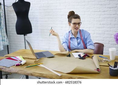 Portrait of talented dressmaker creating sketches for dresses collection sitting at desktop, confident female couturier satisfied with occupation in fashion industry making pret-a-porter clothing  - Shutterstock ID 682518376