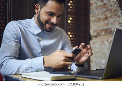 Portrait Of Talented Well Dressed Executive Manager Doing Remote Job While Checking Email Box Waiting For Bank Confirmation Paying Bills Using Smartphone Connected To Wireless Internet In Cafe