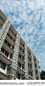 Portrait of A Tall Dormitory Building with Dramatic Cloudy Blue Sky Background