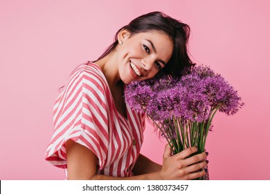 ?lose-up Portrait Of Tanned Woman With Charming Dimples On Her Cheeks. Girl Is Smiling Cute, Tilting Her Head To Flowers