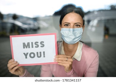 Portrait Of Teacher With Face Mask After Lockdown, Holding Miss You Sign.