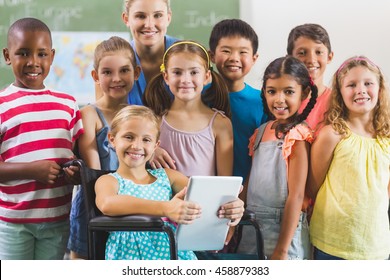 Portrait of teacher and kids in classroom at school