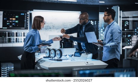 Portrait of Team of Engineers Testing a Prototype for a Delivery Robot in a High-Tech Laboratory. Specialists Brainstorming and Discussing Possibilities for Improvement Using Laptop and Digital Tablet